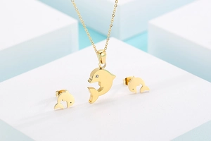 Detailed view of a golden dolphin jewelry set featuring crystal eyes on white cubes