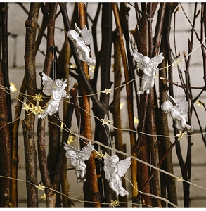 Set of 6 silver Christmas angel ornaments hanging on branches with starry LED lights