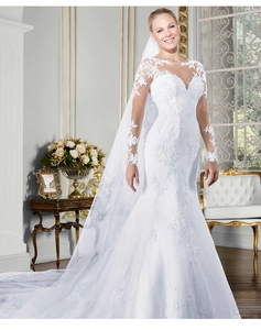 Détail d'une robe de mariée sirène blanche avec broderie en dentelle florale et manches longues