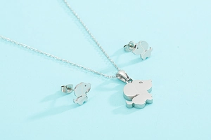 Vue détaillée du collier et des boucles d'oreilles chiot argentés sur fond bleu clair