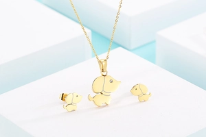 Détail macro du pendentif chien doré et boucles d'oreilles sertis de zircons