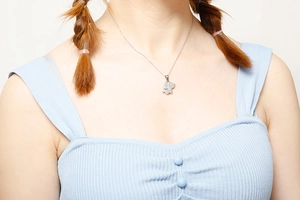 Détail d'un collier avec pendentif chien en argent porté par un mannequin féminin