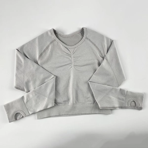 Dettaglio top yoga grigio senza cuciture con design arricciato e fori per i pollici