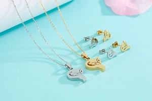 Detailed view of fox pendant necklace and stud earrings set in silver and gold finish