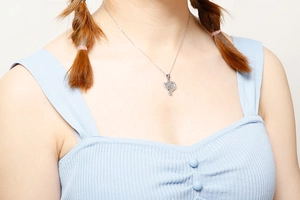 Detailed view of a silver hollow fox pendant necklace worn by a model on white background
