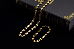 Detailed close-up of golden coffee bean link chain bracelet and necklace set for men