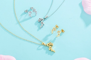 Detailed view of hollow flamingo necklace and earrings set in gold and silver finish