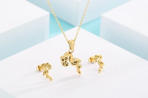 Macro shot of gold flamingo stainless steel necklace and stud earrings jewelry set