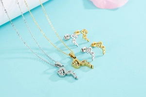 Detailed view of silver and gold flamingo pendant necklaces and stud earrings set