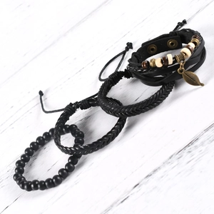 Set of four men's bracelets with woven black leather, wooden beads and leaf charm