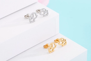 Vue détaillée des boucles d'oreilles chien découpées en argent et or sur support