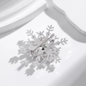 Silver snowflake brooch with rhinestones showing the pin back and metal base structure
