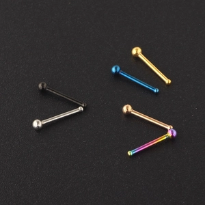 Set of surgical stainless steel nose studs in multiple colors on black texture