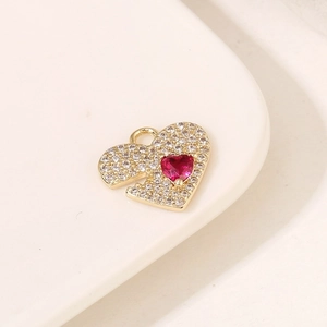 Detail of heart pendant with red gemstone and white crystals on ceramic plate