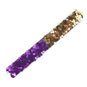 Detail shot of a two-tone gold and purple sequin slap bracelet for kids and party favors