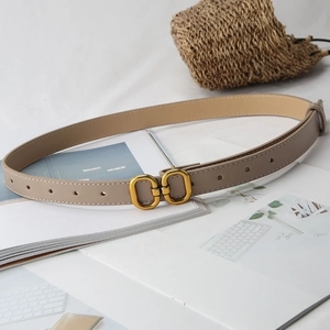 Detail view of beige leather belt with vintage golden double ring buckle on white background