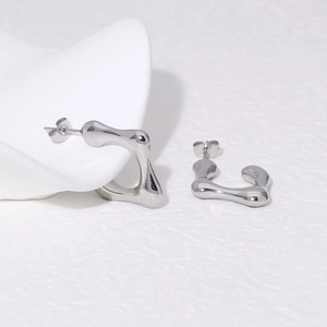 Macro shot of silver liquid metal earrings with irregular lava-style organic texture