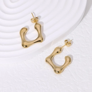 Irregular geometric 18K gold plated stainless steel earrings on white textured base