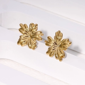 Minimalist 18K gold plated stainless steel flower earrings on a white artistic display
