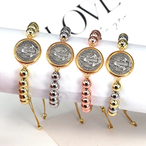Detail of Saint Benedict religious medals on adjustable beaded bracelets in four metal finishes