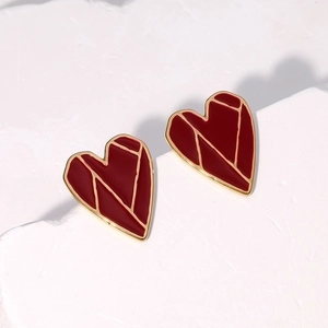 Minimalist red heart stud earrings with 18K gold plating on white marble surface