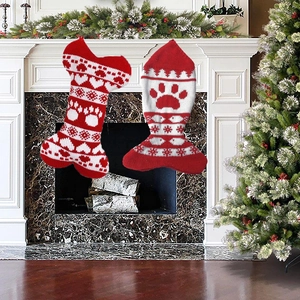 Knitted bone and fish Christmas pet stockings hanging by fireplace with festive decor