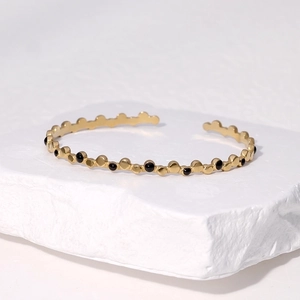 Adjustable 18k gold plated stainless steel cuff bracelet with black enamel dot accents