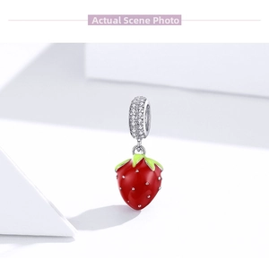 Detailed view of s925 silver strawberry charm with red enamel and sparkling stones