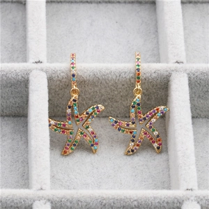 Elegant gold starfish earrings featuring colorful zircon stones on grey velvet display
