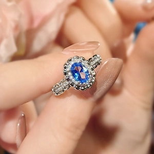 Elegant 3ct oval blue sapphire ring with halo diamonds on a polished silver band
