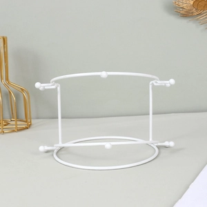 Macro view of white metal crown display stand with round frame and stable ball feet