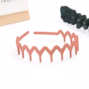 Detail of coral pink wavy headband with matte finish and non-slip serrated teeth