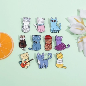Set of 10 cartoon cat enamel pins in various poses and costumes on green background