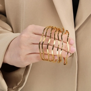 Elegant gold wave-shaped layered titanium steel bangle with minimalist curved design