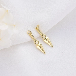 Golden anime-style Kunai dagger pendant pair for DIY jewelry on white fabric background