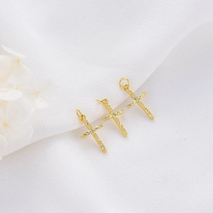 Three gold cross pendants with zircons and textured finish on white background