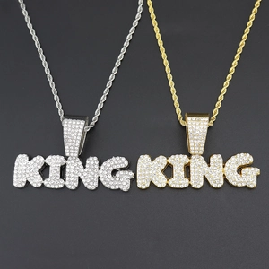 Detailed view of silver and gold plated KING letter pendants with micro-pave crystals