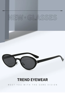 Detail of black oval sunglasses with textured frame edges and dark lenses on a pedestal