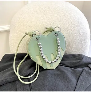 Detail of mint green heart-shaped bag with unique melting layer design and bead handle