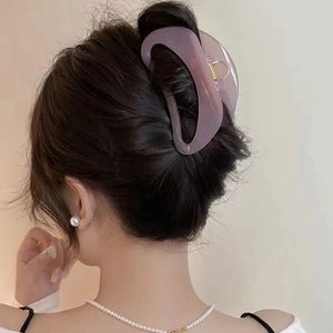 Minimalist large lavender curved hair claw clip for women holding a thick bun hairstyle