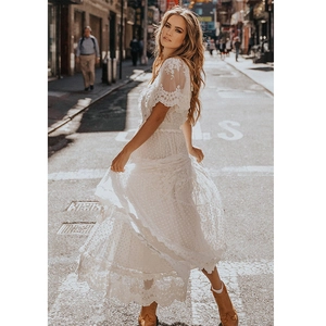 Bohemian white lace V-neck maxi dress with flowy design captured in street style photography