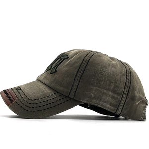 Détail de la casquette en toile délavée vert armée avec broderie M gothique de profil