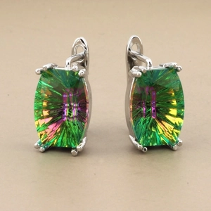 Detailed macro view of silver hoop earrings featuring rectangle-cut green crystal stones