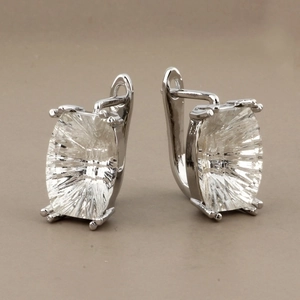 Detailed macro view of silver hoop earrings featuring large radiant-cut clear crystals