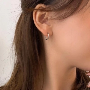 Orecchini a cerchio intrecciati in argento sterling S925 indossati da una modella