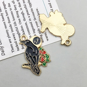 Macro detail of gothic crow and red rose enamel charm with gold alloy back and ring