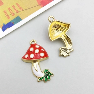 Macro detail of red mushroom pendant with white dots and gold textured backside