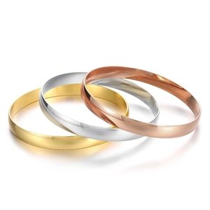Polished 8mm stainless steel bangles in gold, silver, and rose gold stacked on white