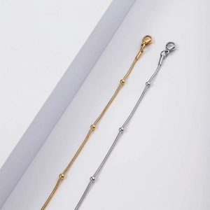 Detail of gold and silver snake bone chain necklaces with beads and lobster clasp closure