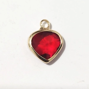 Macro view of heart-shaped red gemstone pendant with gold-plated metal alloy frame